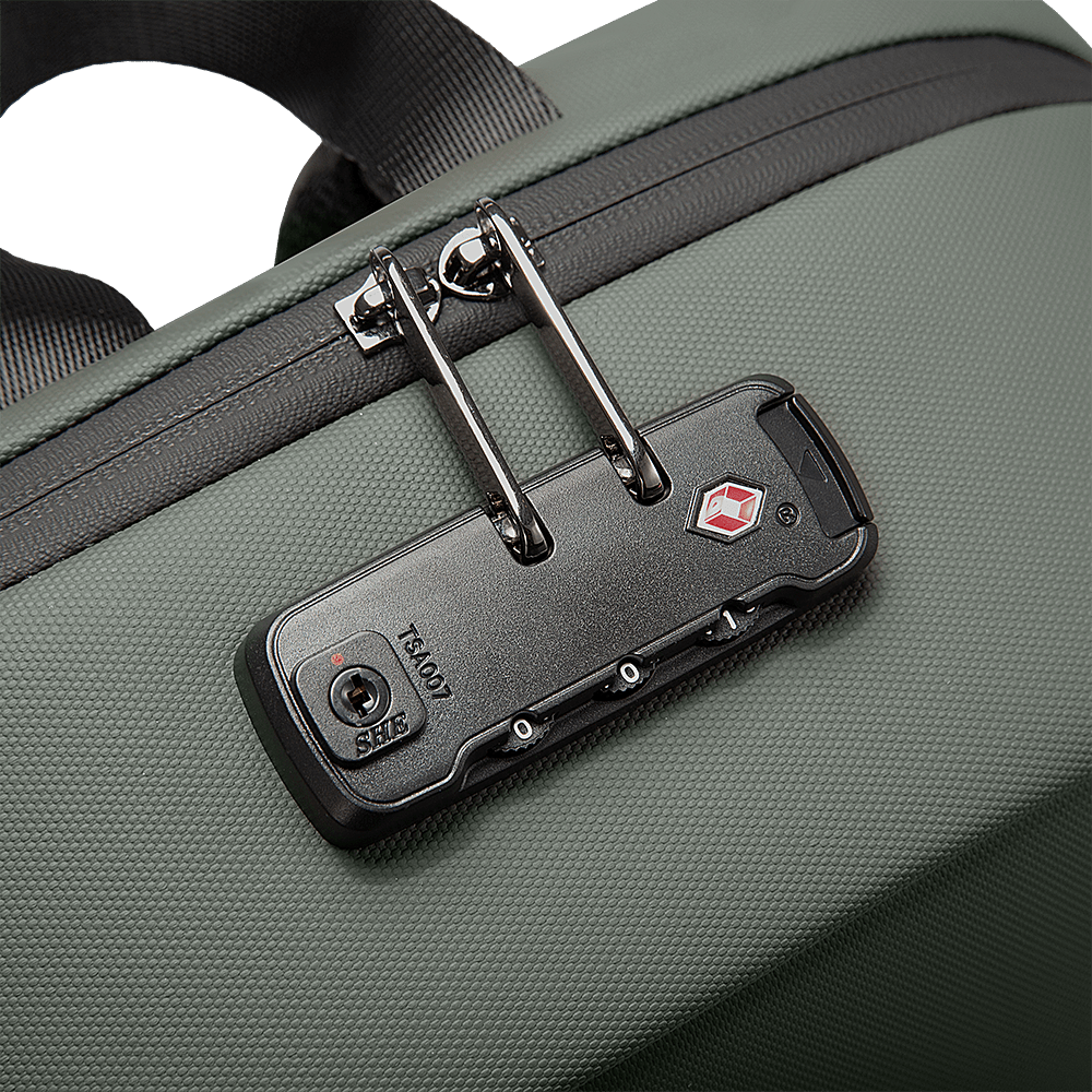 Close-up of TSA007 approved lock on green backpack with double zipper security and textured fabric.