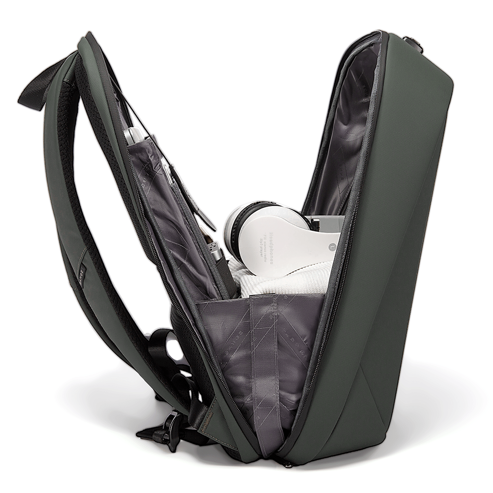 Open green backpack with headphones, clothes, and organized tech pockets in the main compartment.