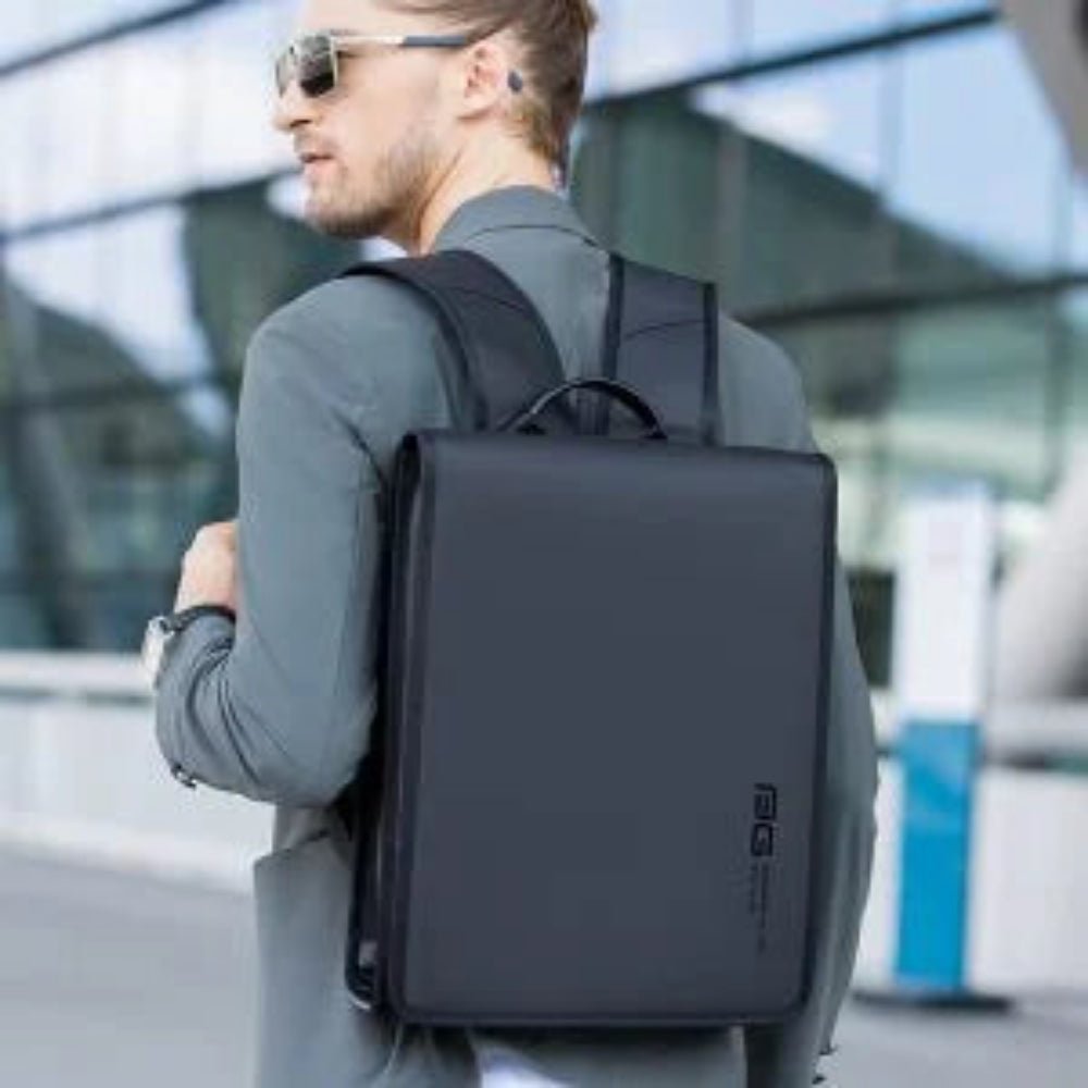 Lifestyle shot of a man wearing a black BANGE BG-7252 backpack outdoors, showcasing a slim modern design for urban commuting and travel